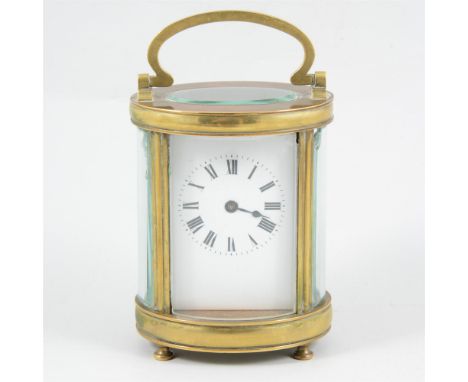 An oval brass cased carriage clock, with bevel glass panels, white enamel dial with Roman numeral chaptering, cylinder escape