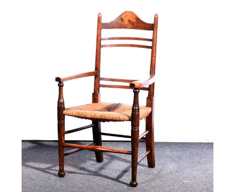 An Arts and Crafts oak rush seated ladder back chair, circa 1890, in the manner of William Birch, the crest rail with an inla