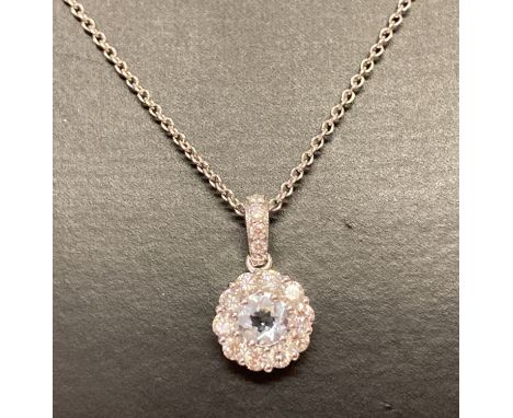 A 18ct white gold aquamarine and diamond pendant necklace by Luke Stockley London. Circular pendant with central .25ct aquama