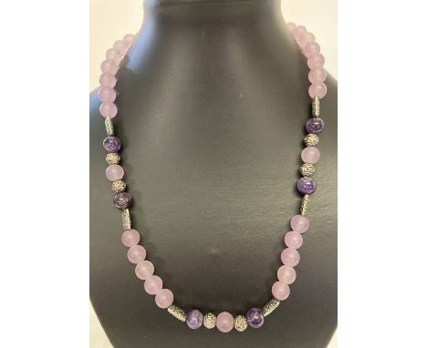 A 20" pink jade and amethyst necklace with white metal decorative beads and S shaped hook clasp.  