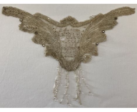 An Edwardian glass bead decorated dress applique panel. Fine white netting hand stitched with barrel, seed and teardrop clear