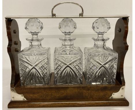 A vintage dark wood and silver plated triple tantalus, marked 'P B &amp; S England'. Complete with 3 matching cut glass decan