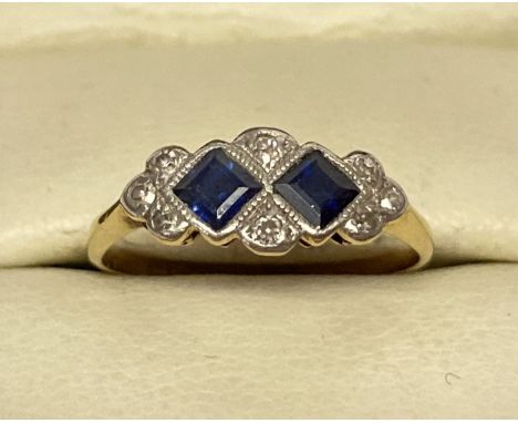 An Art Deco 18ct gold, sapphire and diamond dress ring. 2 square cut sapphires with 8 small round cut diamonds. Inside of ban