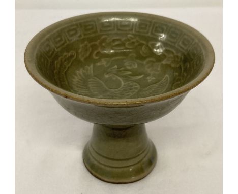 A small Chinese ceramic celadon glazed stem cup with phoenix detail to inner bowl.  Approx. 9cm tall x 11cm diameter.
