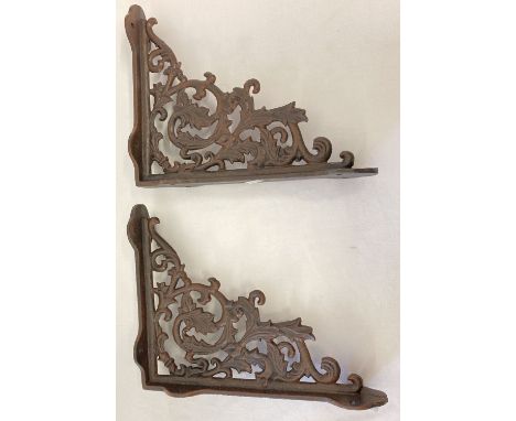 A pair of rust effect cast metal wall shelf bracelets, with decorative scroll &amp; leaf design.  Approx. 28.5cm x 23cm.