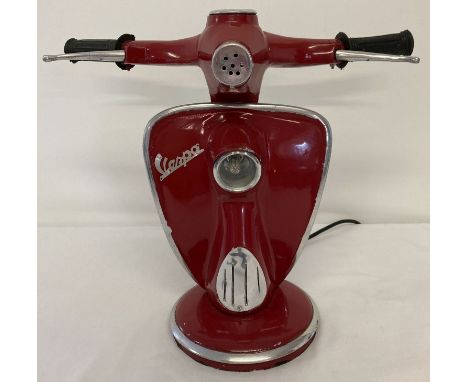 A novelty table lamp in the shape of the handlebars of a Vespa scooter, painted red. With moving brake levers and speedometer