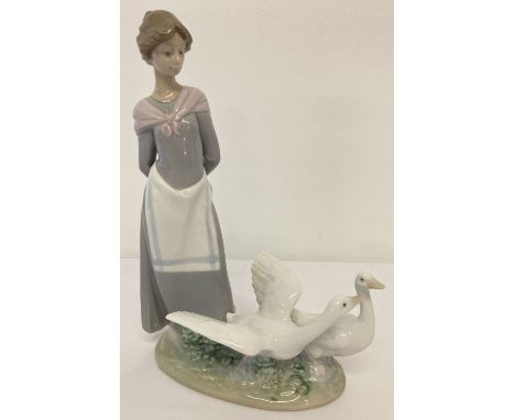 A boxed Lladro ceramic retired figurine #5659 "Barnyard Scene" by sculptor Antonio Ramos. Some foliage missing from her hand 