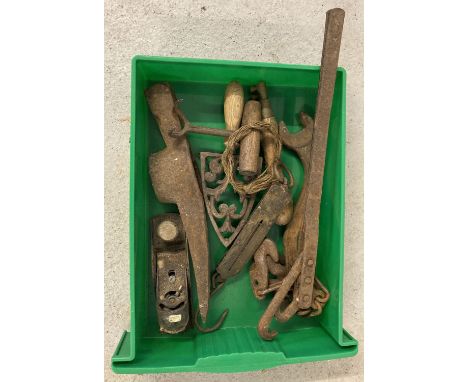 A green tray of vintage tools to include a bag hook, a small block plane and balance scales.  
