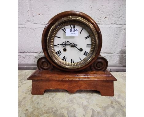 Mantel Clock, in a circular case with scrolled sides, chiming, with a brass border to the painted dial, 30cm x 33cm