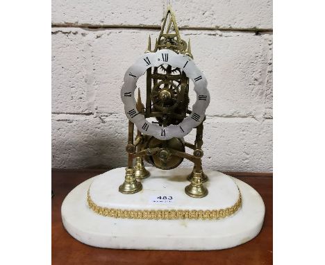 A Brass Framed Skeleton Mantel Clock, with a silvered dial and an oval beige marble base, 33cm x 33cm