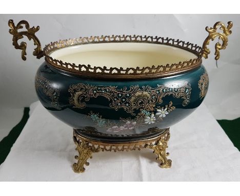 Late 19th C oval shaped French Pottery Jardinière, with galleried brass top, and decorative brass base featuring lion masks, 
