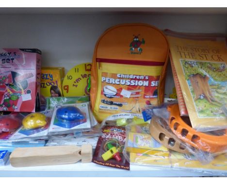 * A shelf containing Child Themed Musical Items including a percussion set, harmonica, ocarinas, castanets, kazoos etc.