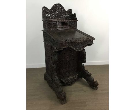 ANGLO-INDIAN DAVENPORT DESK, 19TH CENTURY profusely carved, the pierced raised pediment above three drawers, the hinged writi