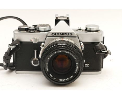 An Olympus OM-1N, with an Olympus Zuiko f/1.8 50mm lens.