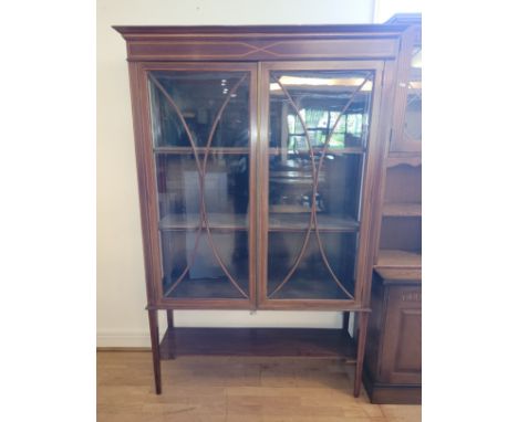 An Edwardian inlaid mahogany display cabinet, having shaped pediment over two glazed doors opening to silk lined interior wit
