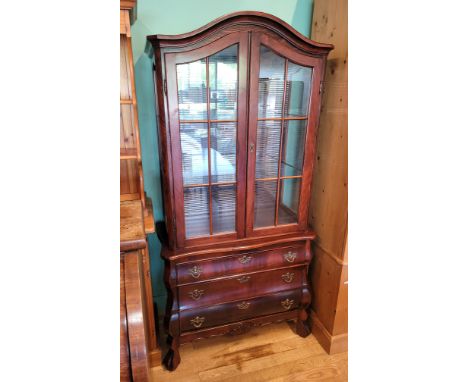 A 20th century French inspired display cabinet, having shaped pediment over two glazed doors opening to a mirror back interio