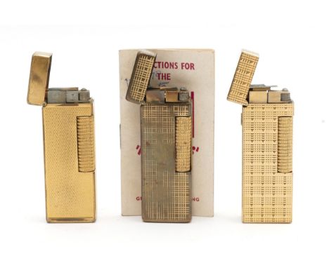 Alfred Dunhill Ltd; Three Dunhill Rollagas pocket cigarette lighters, gold plated with engine turned cases, one having origin