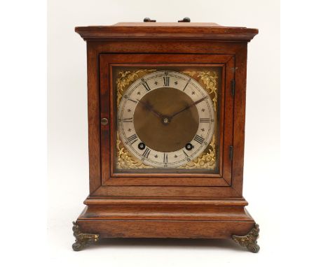 A twentieth century mahogany-cased mantel clock with a silvered chapter ring featuring Roman Numerals and floral spandrels, s