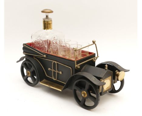 A 1970s novelty spirit drinks decanter set, with six glasses, housed in a vintage car, having wind up musical movement,