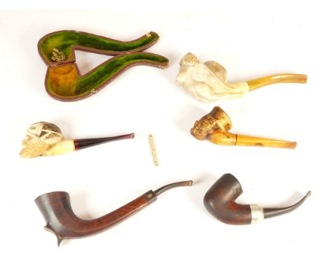 Three meerschaum pipes, one depicting a reclining female form and two depicting carved male heads, one briar pipe with silver