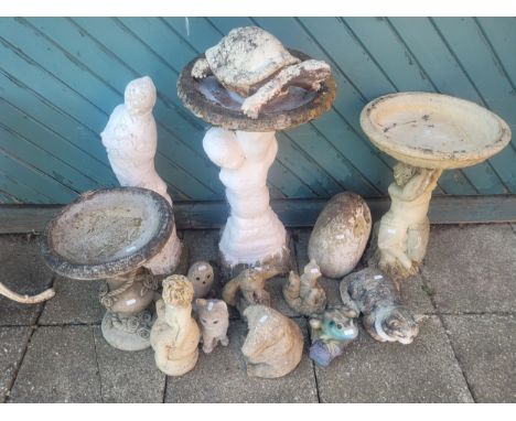 A group of composition stone garden ornaments, including three bird baths, a female statue, and various animal/bird figures.