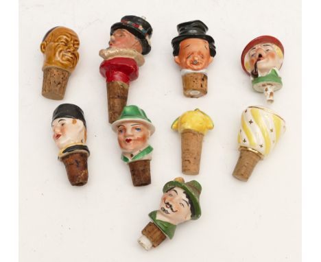 Nine 20th century bottle stoppers, to include ceramic examples in the form of amusing characters.