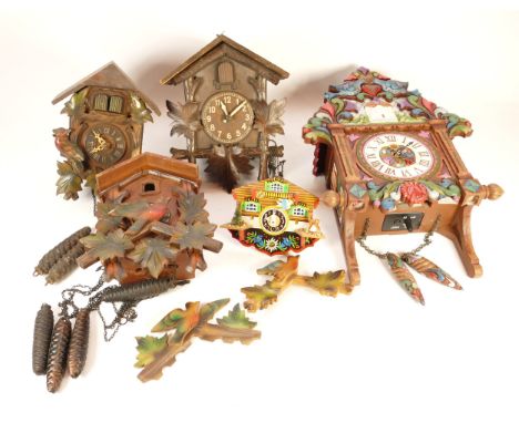 A collection of four mid-twentieth century Black Forest cuckoo clocks, having single and twin train manual wind movement, sui