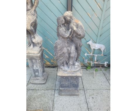 A cast composition stone garden figure of two lovers, raised on a square column base, 109cm tall.