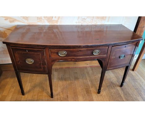 A Victorian inlaid mahogany bow fronted sideboard, the central frieze drawer flanked by two deep drawers with brass drop hand