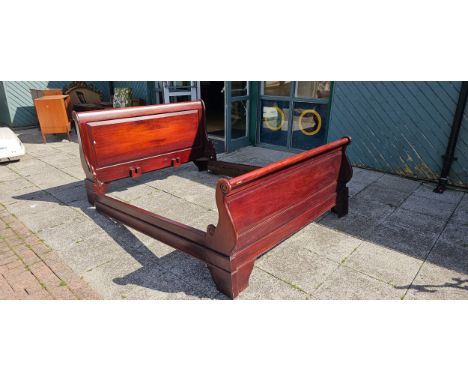 A contemporary Indonesian king size sleigh bed, having panelled head and foot boards with moulded side rails.