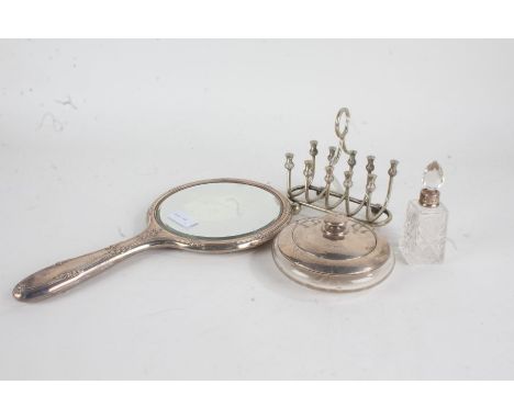 Silver handled hand mirror with cast foliate decoration, silver lidded clear glass powder bowl and cover, perfume bottle with