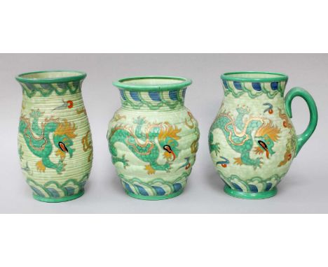 A Crown Ducal Jug, and two vases by Charlotte Rhead, decorated with dragons on green grounds (3) One vase with a repaired chi