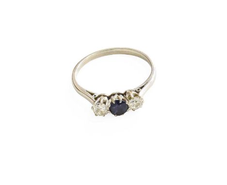 A Sapphire and Diamond Three Stone Ring, the central round cut sapphire flanked by old cut diamonds, in white claw settings, 