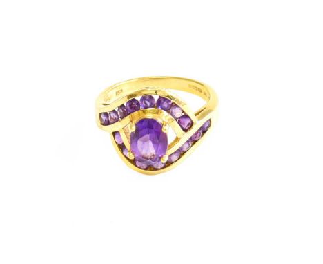 An 18 Carat Gold Amethyst Ring, the oval cut amethyst in a yellow claw setting, to round cut amethyst set twist shoulder plai