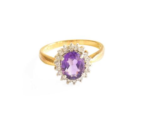 An 18 Carat Gold Amethyst and Diamond Cluster Ring, the oval cut amethyst within a border of round brilliant cut diamonds, in