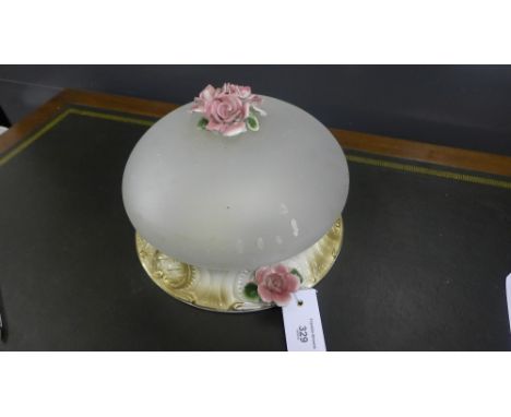An opaque glass and pottery floral encrusted ceiling light shade
