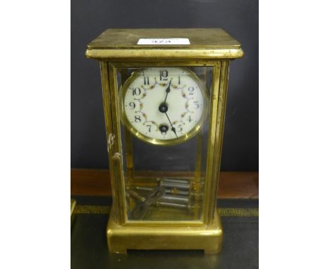 A brass cased and glass panelled mantle clock, the circular white dial with floral swags and Arabic numerals, 21cm high 