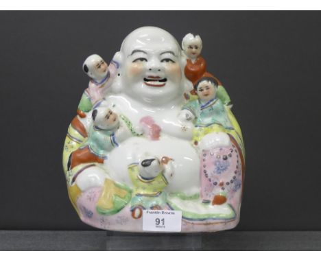 A Chinese figure of Hoti, model seated, with climbing boys, height 22cm 