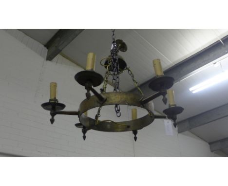 An Arts & Crafts hammered metal light fitting, the circular frame with six faux candle sconces