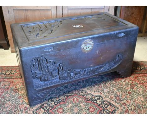 A 1930's Chinese stained and carved camphorwood trunk, with original tray to the interior and brass lock plate (one leg detac