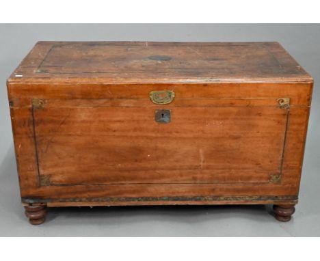 A late 19th century part brass inlaid camphorwood campaign trunk, raised on turned feet, brass handles to sides (one missing)