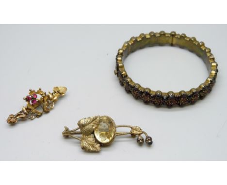 A Bohemian garnet bangle (lacking some stones) and two plated brooches including a Victorian example with horseshoe design, 4