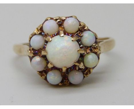 A yellow metal opal cluster ring, partial 9ct stamp, 2.2g, J