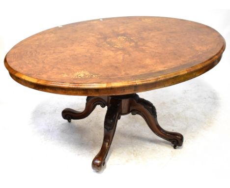 A Victorian inlaid burr walnut oval tilt-top loo table with central floral motif, raised on carved baluster column to four ca