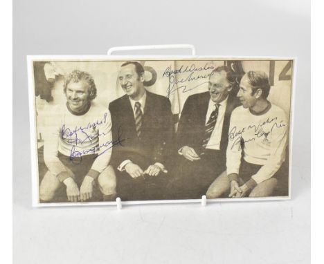 ENGLAND FOOTBALL; a black and white photograph removed from a newspaper, laid on card and bearing the signatures of Sir Bobby