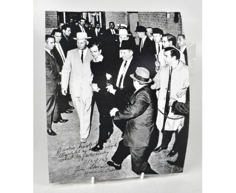 AMERICAN HISTORY; a reproduced black and white photograph depicting the moment Jack Ruby shot Lee Harvey Oswald, inscribed 'I