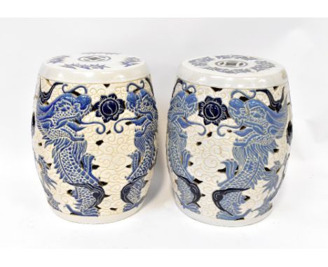 A pair of Chinese decorative ceramic garden seats, incised and pierced with blue dragon decoration within clouds, height 42cm