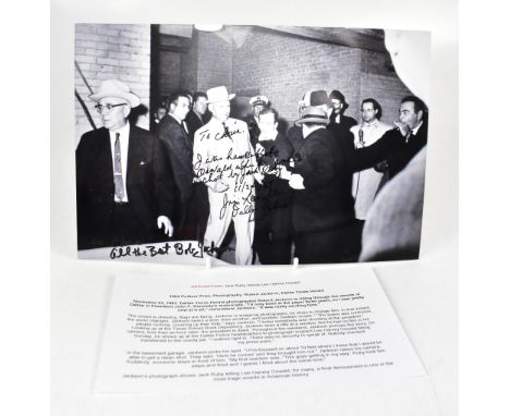 A reproduction black and white photograph depicting the moment that Jack Ruby shot Lee Harvey Oswald, inscribed 'I was handcu