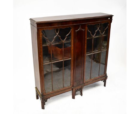 A 19th century Chippendale-style mahogany floorstanding cabinet, the bow front with a pair of astragal glazed doors, with cen