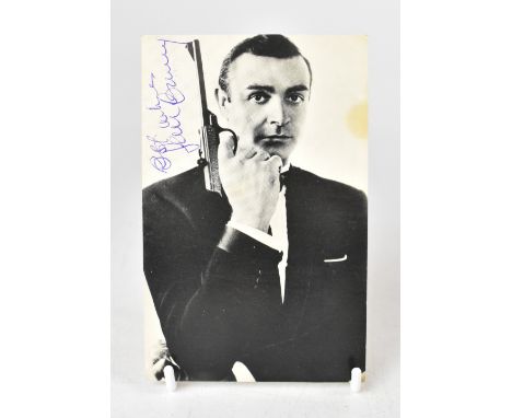 SEAN CONNERY; a black and white photographic postcard bearing the star's signature with the image of him playing James Bond. 
